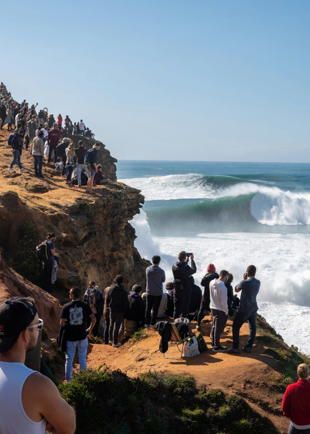 Clifftop of Nazare with people watching Big Waves.
